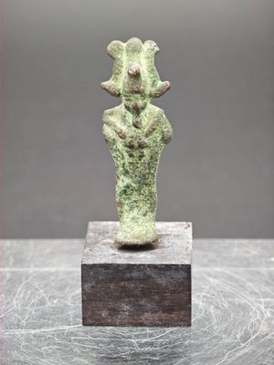 un gros plan d'une statue posée sur un bloc de bois, sur une table