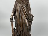 a bronze statue of a woman holding a sword and shield