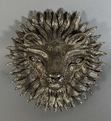 une broche en forme de tête de lion en argent sur fond gris