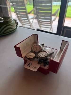 trois montres dans un coffret rouge posé sur une table