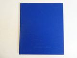 le livre bleu est posé sur une surface blanche, avec un fond blanc