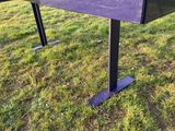une photo d'un banc en métal posé dans l'herbe