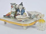figurines en porcelaine représentant deux personnes assises sur un plateau, avec des bols et des vases