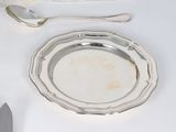 a silver plate with a silver spoon and a silver plate with a silver spoon and a silver plate with a silver spoon and a silver plate with a silver