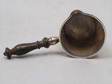 silver plated tea strainer with wooden handle on a white surface