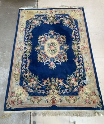 Un tapis chinois en laine à décor floral et d'un médaillon c…