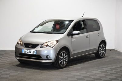la petite voiture argentée est garée sur un sol en damier