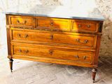 a wooden dresser with marble top on a brick floor