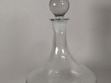 a glass bottle with a ball on top of it