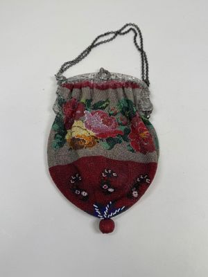 un vieux sac à main accroché à un mur, sur une surface blanche