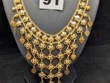 un collier en or sur un mannequin de vitrine, avec une étiquette de prix
