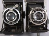two old cameras sitting next to each other on a table