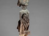 a wooden statue of a woman with a hat on her head