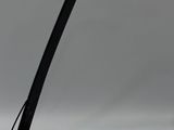 une photo d'une lampe de bureau noire posée sur une surface blanche