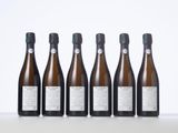 six bottles of wine lined up in a row on a table