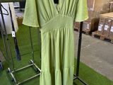 lime green dress hanging on a rack in a warehouse