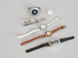 trois montres et une montre posées sur une surface blanche