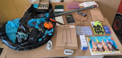 une table sur laquelle se trouvent un sac, un sac à dos, un téléphone portable et d'autres objets