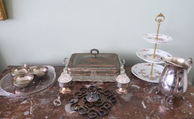 une table en marbre sur laquelle sont disposés de la vaisselle et des couverts en argent