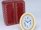 une petite horloge posée à côté d'une boîte rouge