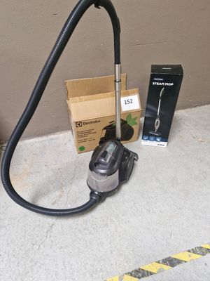un aspirateur posé par terre à côté d'une boîte