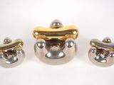 three pieces of silver and gold on a white surface