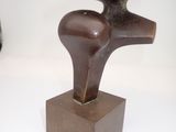 a bronze sculpture of a bird on a wooden base