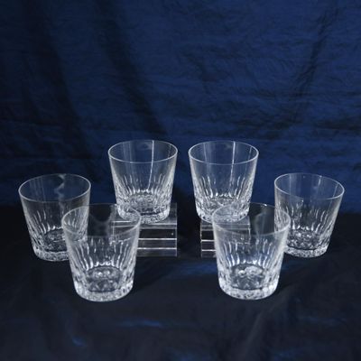 six verres de tailles et de formes différentes posés sur une surface noire