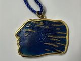 un collier bleu et or orné d'un visage de femme