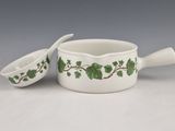 pair of white and green ceramic dishes with green leaves on them