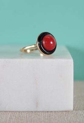black and red stone ring on a white marble block