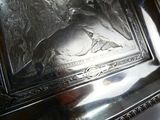 une assiette en argent sur laquelle est représenté un homme et une femme