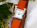 a watch that is sitting on a table next to a plant