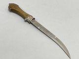 a knife with a wooden handle on a white surface