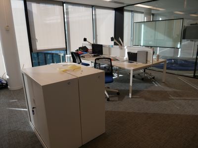 une salle où se trouvent de nombreux bureaux et chaises