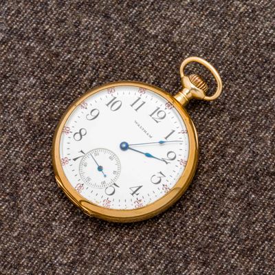 un gros plan d'une montre de poche posée sur un tissu