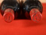 two bottles of wine sitting next to each other on a table