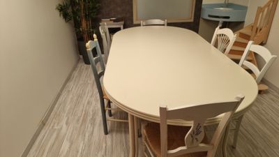 une table et des chaises dans une pièce où il y a un miroir accroché au mur