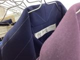 three suits hanging on a clothes rack in a closet