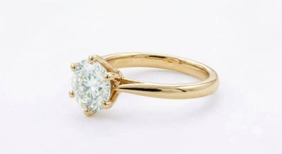 une bague de fiançailles en or sertie d'un diamant rond taille brillant