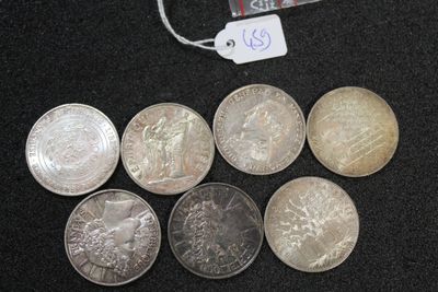 six different coins sitting next to each other on a black surface