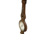 a wooden clock hanging from the side of a pole