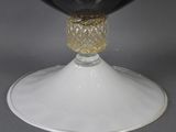 a wine glass with a gold decoration on top of it