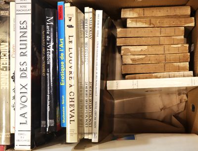 de nombreux livres qui se trouvent dans une boîte posée sur une étagère