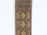 an old book sitting on top of a white surface