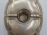 an antique silver cigarette case with a hole in the middle
