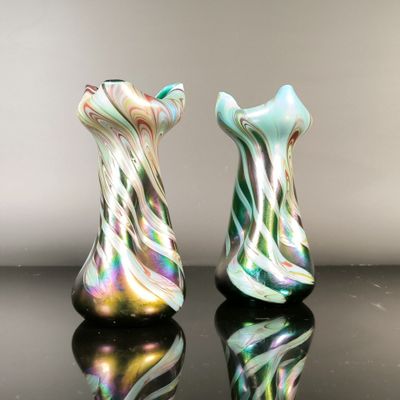 two glass vases that are sitting on a table