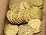 beaucoup de pièces d'or dans une boîte posée sur la table
