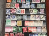 un livre ouvert posé sur une table recouverte de timbres