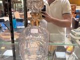a man standing behind a glass case holding a cell phone
